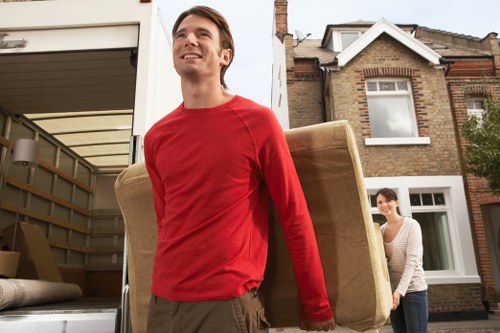 Removal crew handling desks and office items in a London workspace